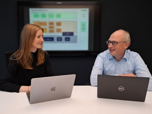 Merle Rüter und Stefan Meyer im Arbeitsmeeting mit Notebooks vor Prozesschart